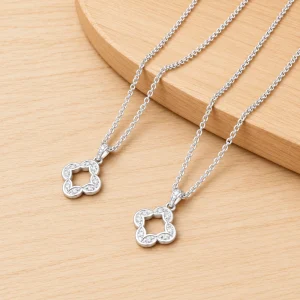 Hai dây chuyền bạc nữ 925 mặt hoa bốn cánh rỗng viền đá, nền gỗ sáng, ảnh rõ nét 1254px