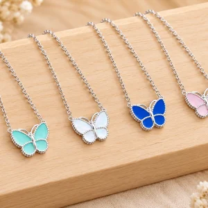 Bốn mẫu dây chuyền bạc nữ 925 mặt bướm màu xanh ngọc, trắng, xanh lam và hồng trên nền gỗ sáng
