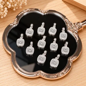 Mặt dây chuyền bạc 925 dáng vuông bo góc với viền đá lấp lánh trên khay nền gỗ sáng