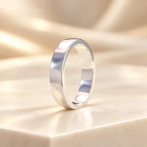 Nhẫn bạc 925 trơn bản dẹt bề mặt bóng sáng trên nền kem sang trọng, không đính đá