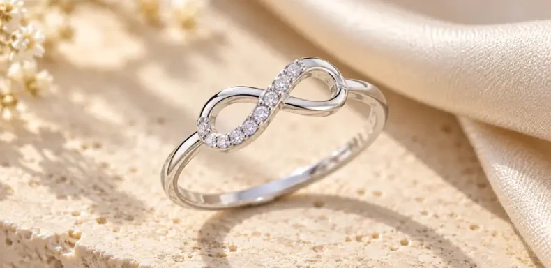 Ảnh minh họa nhẫn bạc hình vô cực đính đá trắng nhỏ trên nền đá sáng